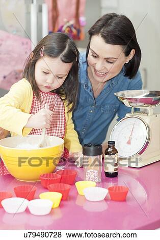 Stock Photo - Mother and daughter baking. Fotosearch