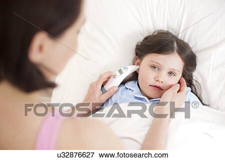 Mother taking daughter's temperature View Large Photo Image Stock Photo - Mother taking daughter's temperature. Fotosearch