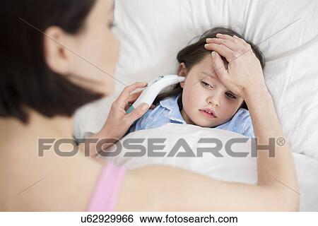 Stock Photograph - Mother taking daughter's temperature. Fotosearch
