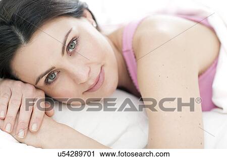 Stock Image - Woman lying in bed. Fotosearch