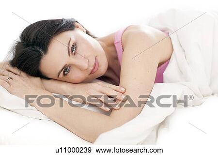 Stock Photo - Woman lying in bed. Fotosearch