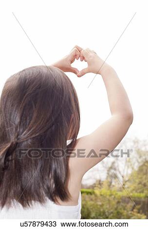 Young girl making heart shape View Large Photo Image Stock Image - Young girl making heart shape. Fotosearch