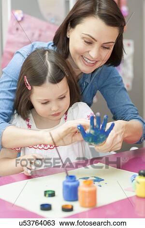 Stock Image - Young girl painting. Fotosearch