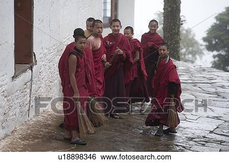 Stock Photograph - Buddhist monks sweeping at Talo Monastery, Punakha Valley, Punakha District, Bhutan. Fotosearch
