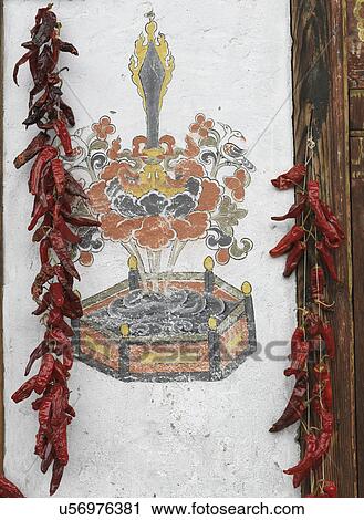 Stock Image - Chili peppers hanging on a wall, Chokhor Town, Bumthang District, Bhutan. Fotosearch