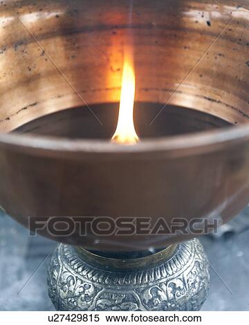 Stock Photography - Close-up of an oil lamp burning at Taktsang Monastery, Paro Valley, Paro District, Bhutan. Fotosearch