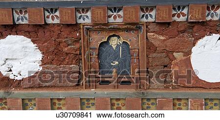 Stock Image - Close-up of Buddha sculpture on a wall at Dochula Pass, Thimphu, Bhutan. Fotosearch