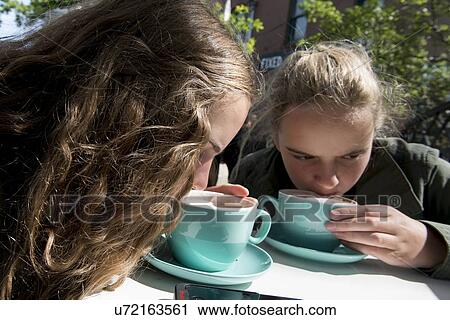 Stock Image - Close-up of two girls enjoying coffee, St. John's, Newfoundland and Labrador, Canada. Fotosearch