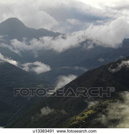 Stock Image - Clouds over mountains, Trongsa District, Bhutan. Fotosearch
