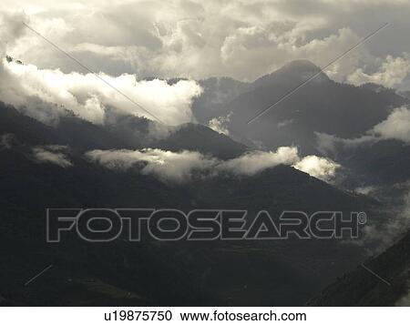 Stock Image - Clouds over mountains, Trongsa District, Bhutan. Fotosearch