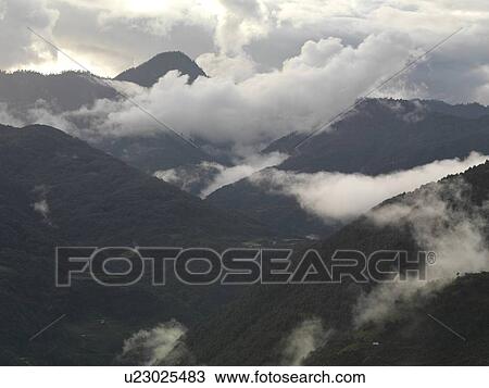 Stock Image - Clouds over mountains, Trongsa District, Bhutan. Fotosearch