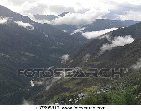 Stock Photo - Clouds over mountains, Trongsa District, Bhutan. Fotosearch