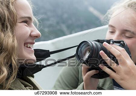 Stock Photo - Girls taking a picture during Western Brook Pond fjord boat tour, Gros Morne National Park, Newfoundland and Labrador, Canada. Fotosearch