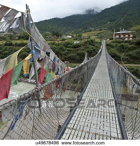 Stock Photo - Good luck prayer flags at a suspension bridge in Punakha District, Puntshang Chhu River. Fotosearch