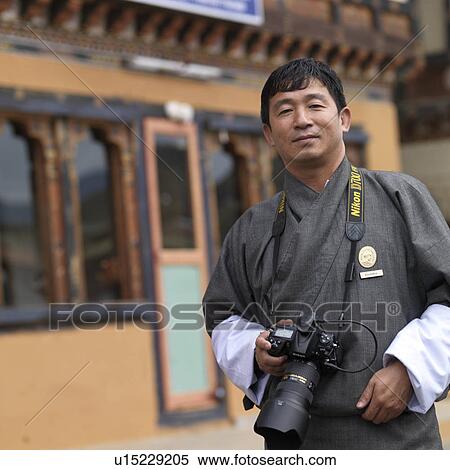 Man holding a camera, Paro Valley, Paro District, Bhutan View Large Photo Image Stock Photography - Man holding a camera, Paro Valley, Paro District, Bhutan. Fotosearch