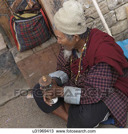 Man holding a prayer wheel, National Memorial Chorten, Thimphu, Bhutan View Large Photo Image Stock Image - Man holding a prayer wheel, National Memorial Chorten, Thimphu, Bhutan. Fotosearch