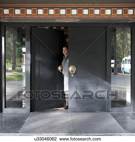 Stock Image - Man standing at a doorway, Bhutan. Fotosearch