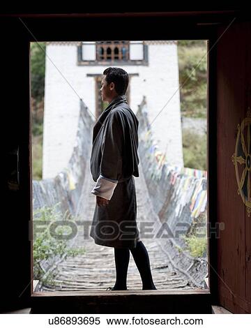 Stock Photography - Man standing on a bridge, Tamchhog Lhakhang, Paro Valley, Paro District, Bhutan. Fotosearch