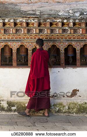 Monk standing in front of prayer wheels at Wangdue Dzong, Wangdue Phodrang, Bhutan View Large Photo Image Stock Photo - Monk standing in front of prayer wheels at Wangdue Dzong, Wangdue Phodrang, Bhutan. Fotosearch