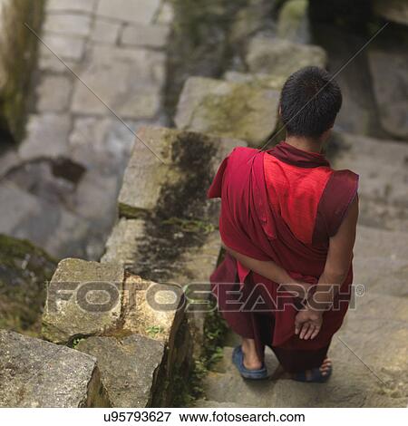 Stock Photo - Rear view of a monk moving down steps at Tango Goemba, Thimphu, Bhutan. Fotosearch
