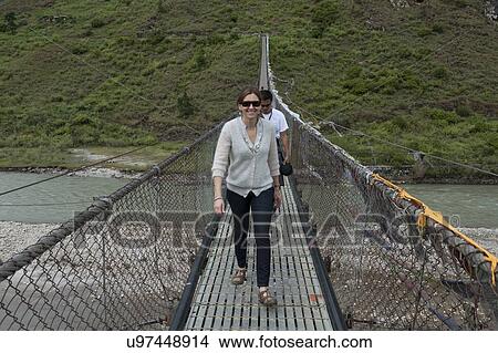 Tourists crossing the bridge across Puna Tsang River, Punakha District, Bhutan View Large Photo Image Picture - Tourists crossing the bridge across Puna Tsang River, Punakha District, Bhutan. Fotosearch