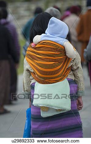 Woman carrying her child on back, National Memorial Chorten, Thimphu, Bhutan View Large Photo Image Stock Image - Woman carrying her child on back, National Memorial Chorten, Thimphu, Bhutan. Fotosearch