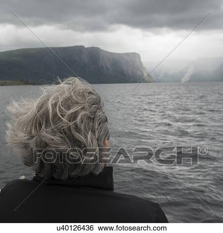 Stock Photograph - Woman enjoying Western Brook Pond fjord boat tour, Gros Morne National Park, Newfoundland and Labrador, Canada. Fotosearch