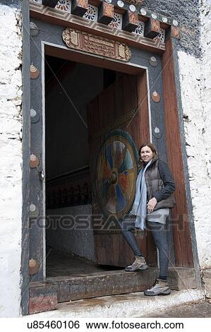 Woman standing at an entrance gate of Trongsa Dzong, Trongsa, Bhutan View Large Photo Image Stock Photograph - Woman standing at an entrance gate of Trongsa Dzong, Trongsa, Bhutan. Fotosearch