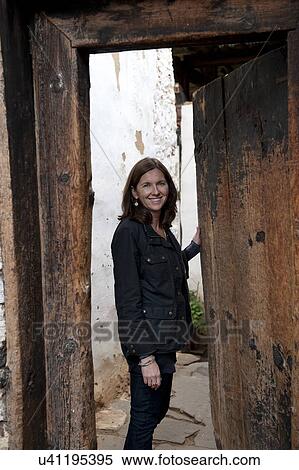 Stock Photography - Woman standing at an entrance gate of Tamchhog Lhakhang, Paro Valley, Paro District, Bhutan. Fotosearch