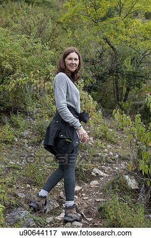 Stock Photo - Woman walking in a forest, Paro Valley, Paro District, Bhutan. Fotosearch