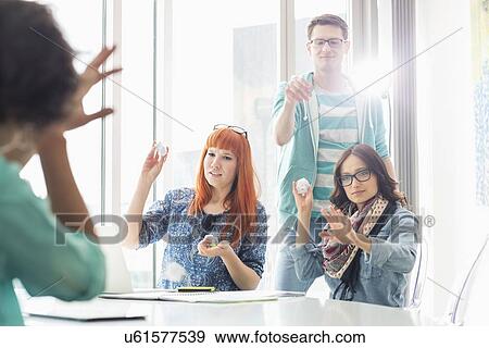Angry businesspeople throwing paper balls on colleague in creative office View Large Photo Image Stock Photo - Angry businesspeople throwing paper balls on colleague in creative office. Fotosearch