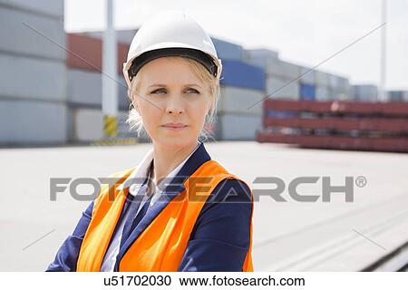 Beautiful female engineer looking away in shipping yard View Large Photo Image Stock Image - Beautiful female engineer looking away in shipping yard. Fotosearch