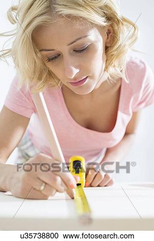 Beautiful woman marking table with measure tape View Large Photo Image Stock Image - Beautiful woman marking table with measure tape. Fotosearch