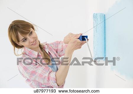 Beautiful woman painting wall with paint roller View Large Photo Image Stock Image - Beautiful woman painting wall with paint roller. Fotosearch