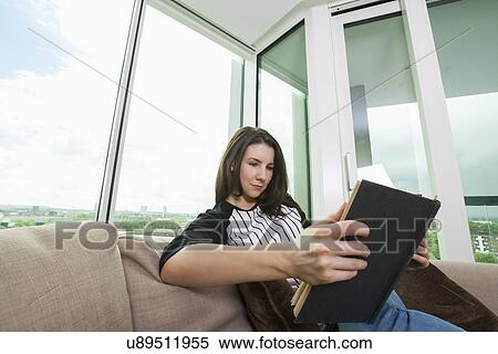 Beautiful woman reading book on sofa at home View Large Photo Image Stock Photography - Beautiful woman reading book on sofa at home. Fotosearch