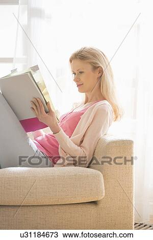 Beautiful woman reading magazine at home View Large Photo Image Stock Image - Beautiful woman reading magazine at home. Fotosearch