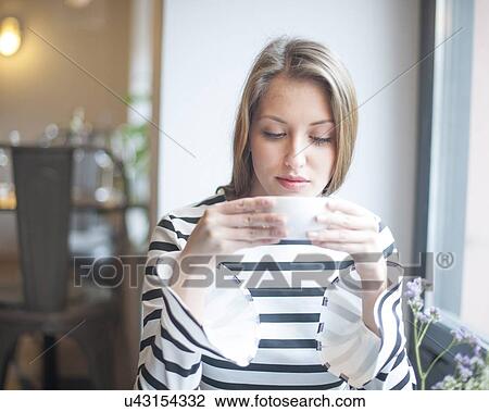 Beautiful young woman drinking coffee in cafe View Large Photo Image Stock Image - Beautiful young woman drinking coffee in cafe. Fotosearch