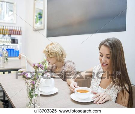 Beautiful young woman having coffee in cafe View Large Photo Image Stock Photography - Beautiful young woman having coffee in cafe. Fotosearch