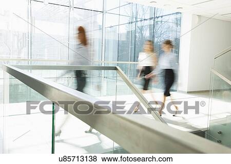 Blurred motion of businesswomen walking at office hallway View Large Photo Image Stock Photo - Blurred motion of businesswomen walking at office hallway. Fotosearch