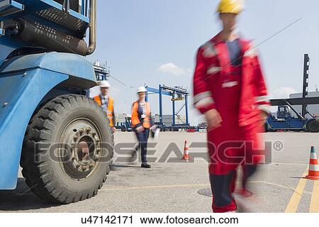 Blurred motion of workers walking in shipping yard View Large Photo Image Stock Image - Blurred motion of workers walking in shipping yard. Fotosearch