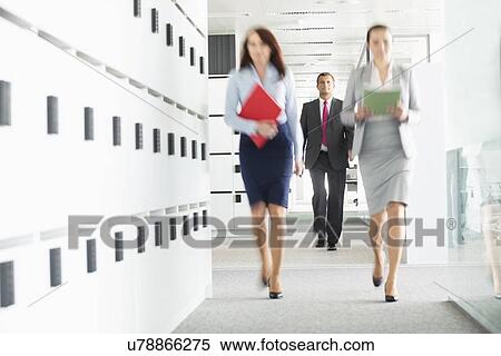 Blurred view of businesswomen walking in office View Large Photo Image Stock Photography - Blurred view of businesswomen walking in office. Fotosearch