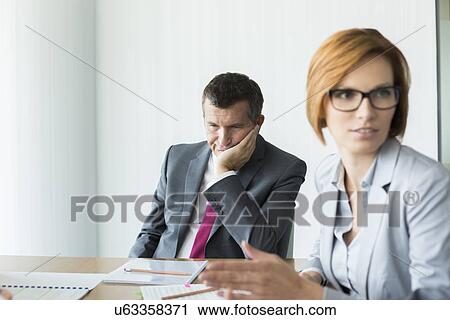 Bored businessman in conference meeting View Large Photo Image Stock Image - Bored businessman in conference meeting. Fotosearch