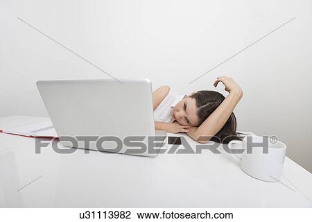 Bored businesswoman looking at laptop in office View Large Photo Image Stock Image - Bored businesswoman looking at laptop in office. Fotosearch