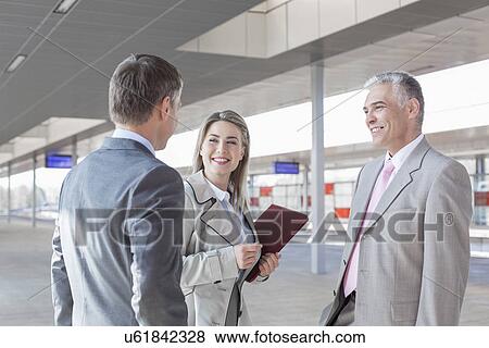 Business people conversing on train platform View Large Photo Image Stock Photo - Business people conversing on train platform. Fotosearch