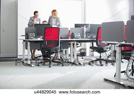 Business people having lunch while using computer in office View Large Photo Image Stock Photography - Business people having lunch while using computer in office. Fotosearch