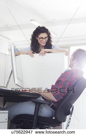 Stock Photo - Business people talking over cubicle wall. Fotosearch