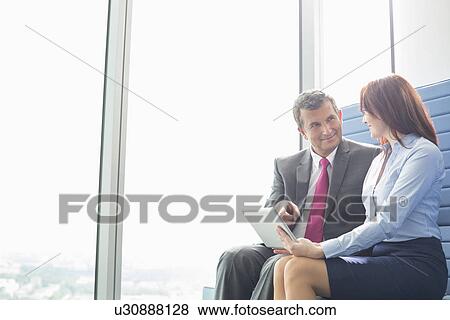 Stock Photo - Business people using tablet PC in office. Fotosearch