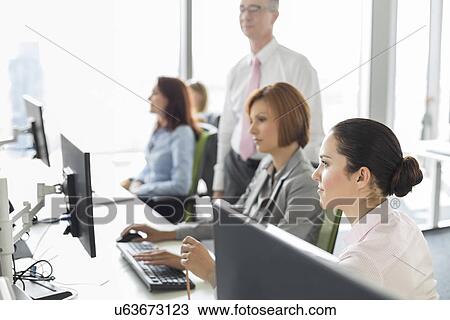 Stock Image - Business people working in office. Fotosearch