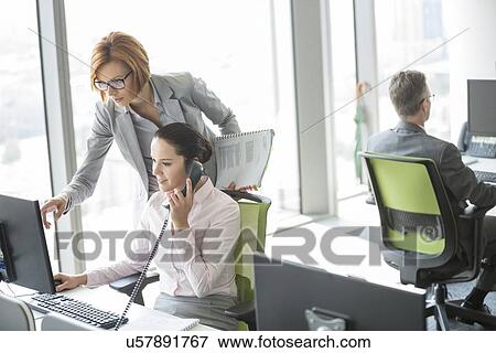 Stock Photo - Business people working in office. Fotosearch