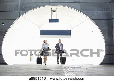 Picture - Businessman and businesswoman rushing in railroad station. Fotosearch